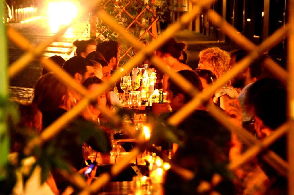 Blick durch das Fenstergitter in das warm beleuchtete Café Jacques