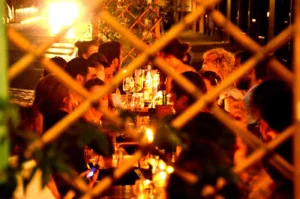 Blick durch das Fenstergitter in das warm beleuchtete Café Jacques