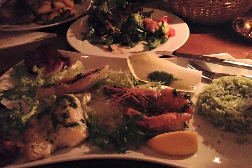 Fischgericht mit Gemüse und Zitronenspalte im Café Jacques